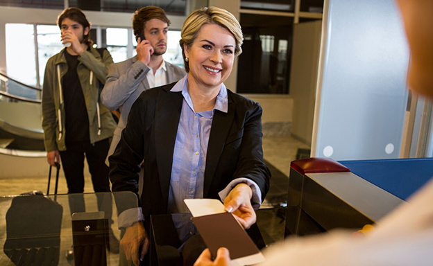 A smiling woman at the airport check-in counter, journey made easy by migration consultants in Kochi.